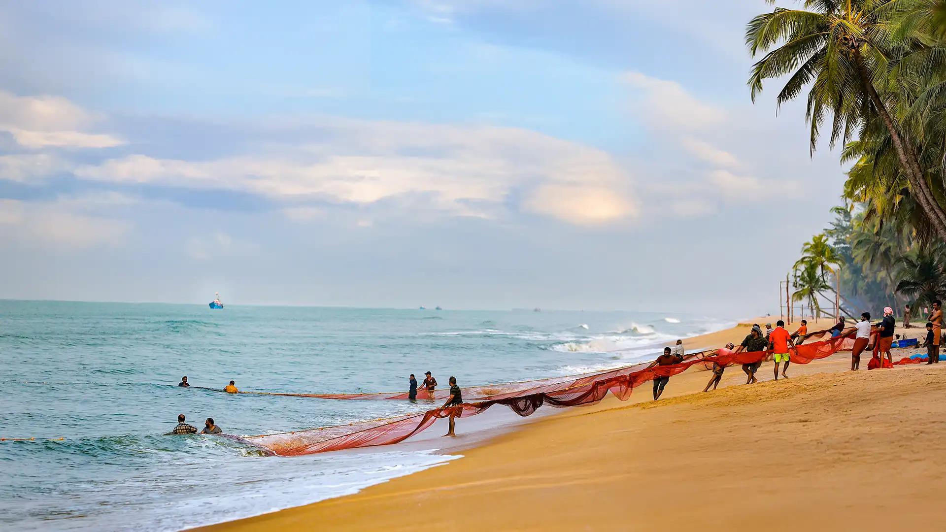 Fishermen at Valiyaparamba Beach: Coastal Life Meets Leisure Fishermen at Valiyaparamba Beach: Coastal Life Meets Leisure