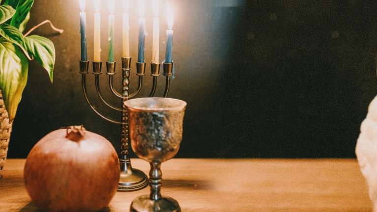 Lighting the candles of a candelabrum with nine branches during Hanukkah festival